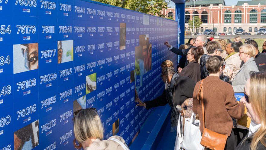 Guests at United Way of Tarrant County's centennial celebration remove magnetic from a piece of art that will be on display beginning Nov. 17 at Globe Life Field.