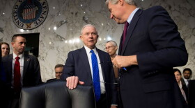 Attorney General Jeff Sessions (center) speaks with Democratic Sen. Sheldon Whitehouse of Rhode Island as he arrives to testify during a Senate Judiciary Committee hearing on Capitol Hill on Oct. 18, 2017. (Saul Loeb/AFP/Getty Images)