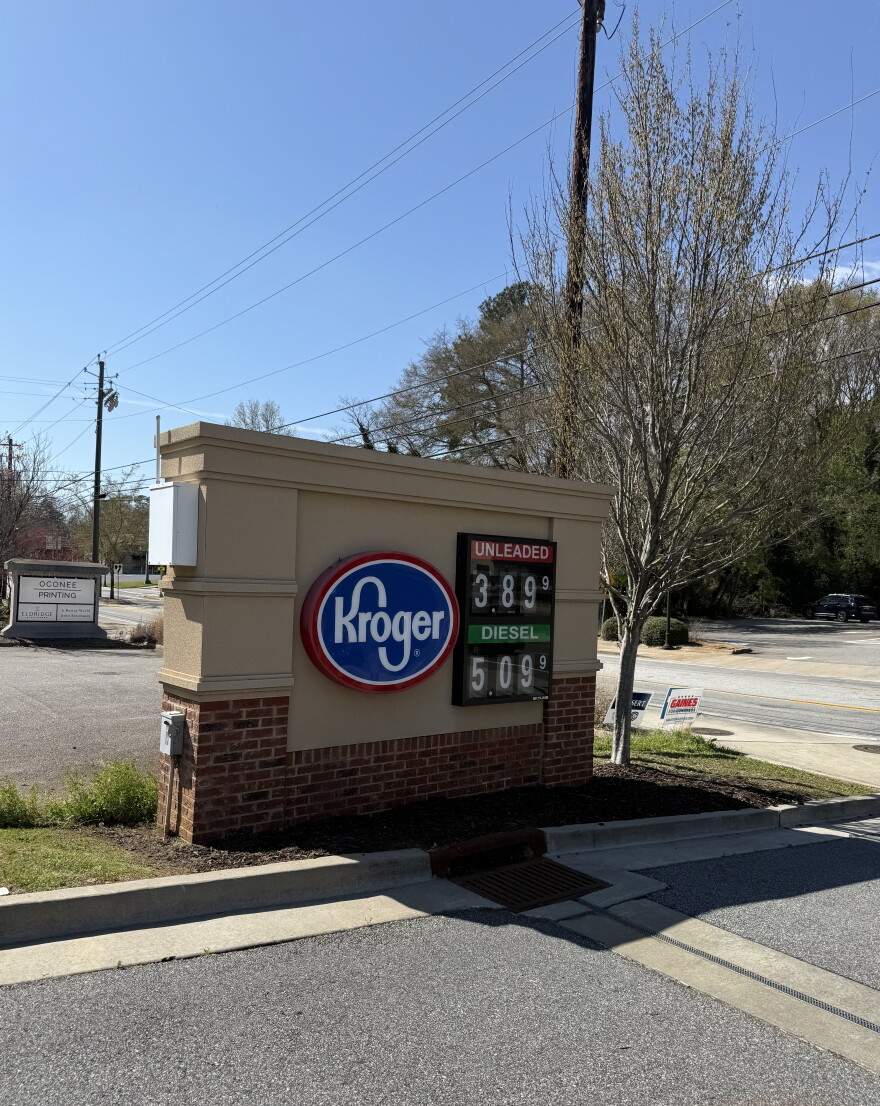 A brown and tan Kroger fuel sign displays gas prices beside a roadway in Athens.