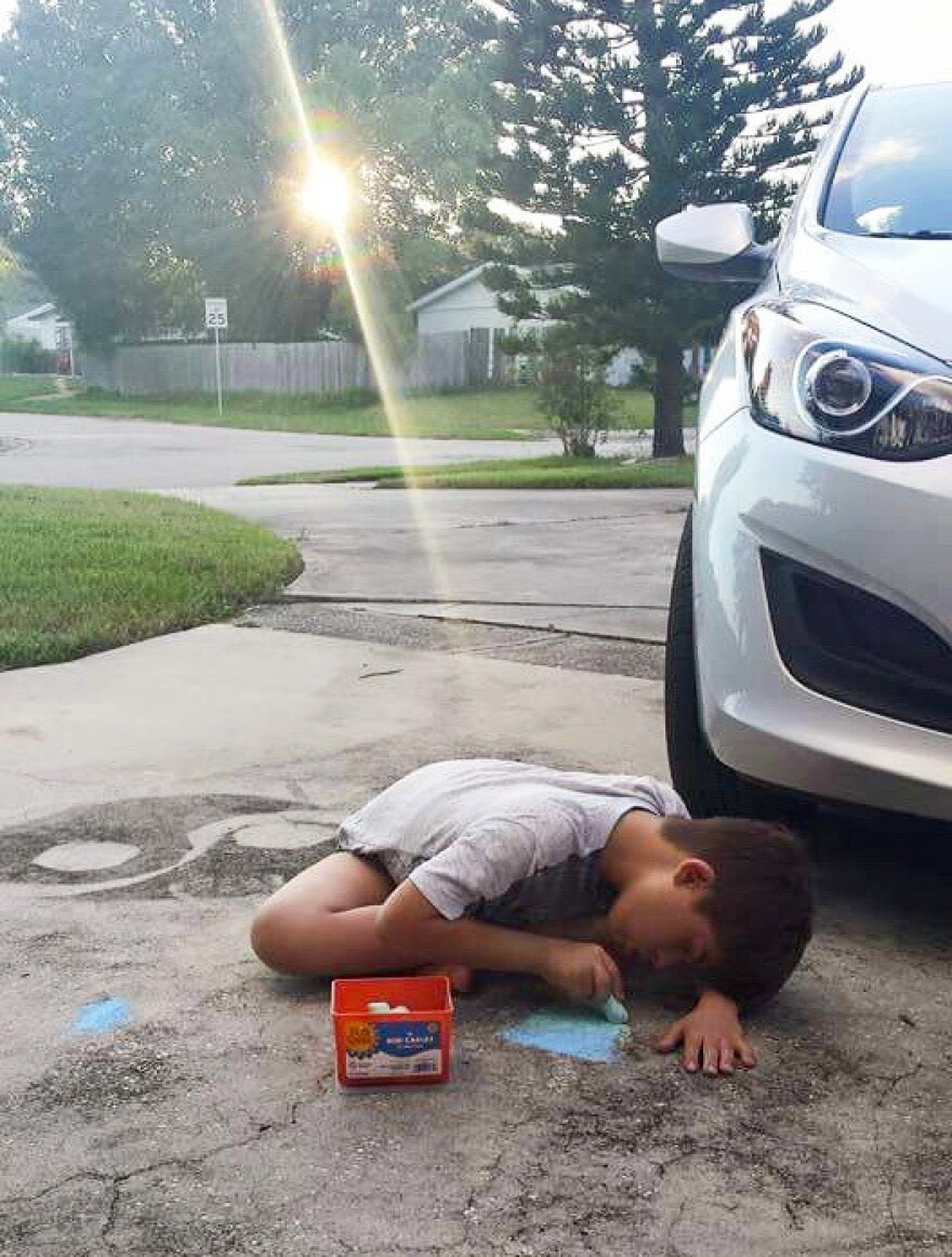 Ryan Torres, drawing in his driveway, recently went to the ER at Nemours Children's Hospital in Orlando.