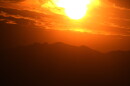 The setting sun illuminates the clouds over the Rocky Mountains.