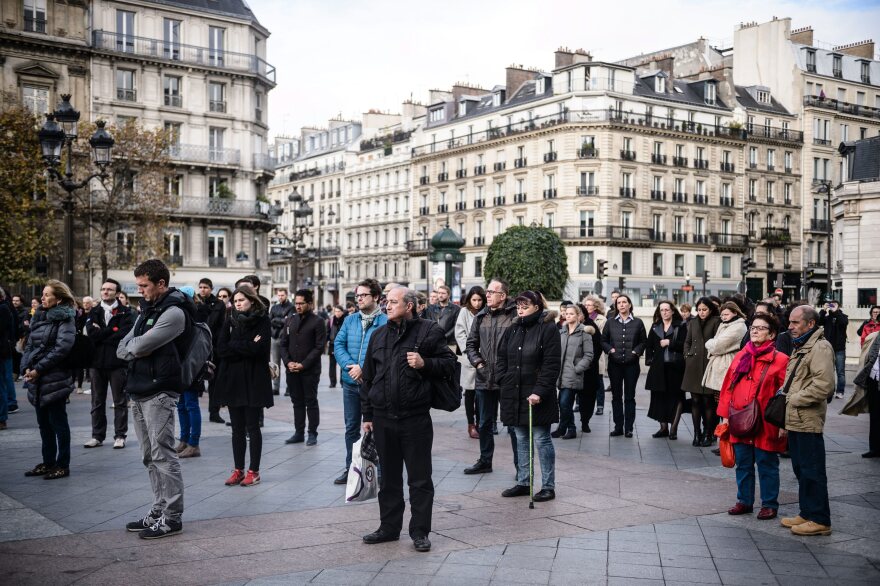 People gather to hold a minute of silence in front of the Paris city Hall, France, on Monday.