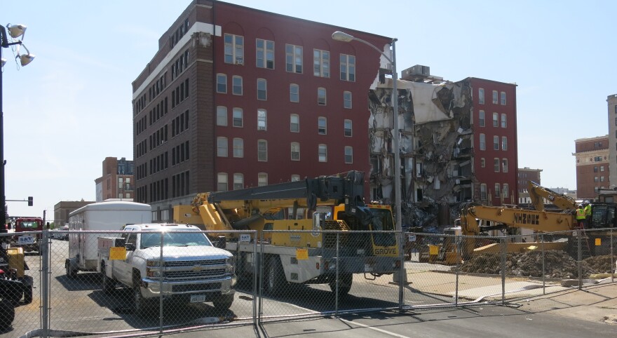 Tarps have been placed over the fence in front of City Hall, and Nathalia Rivera of Moline, who was standing on a chair, took this photo of the site where crews are working at the partially collapsed Davenport building.