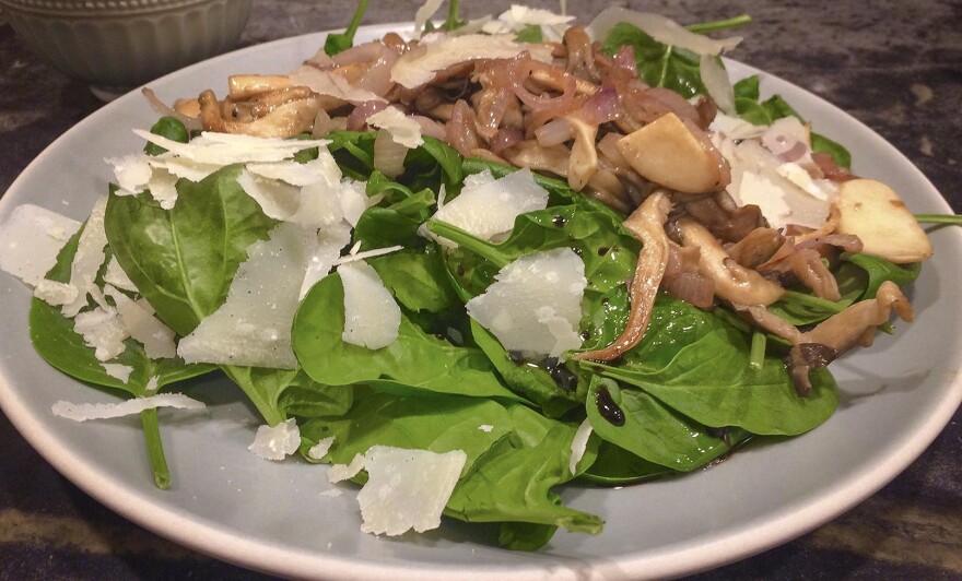 Kathy's sauteed mushrooms over baby spinach with warm garlic vinaigrette and parmesan shavings. (Kathy Gunst for Here & Now)