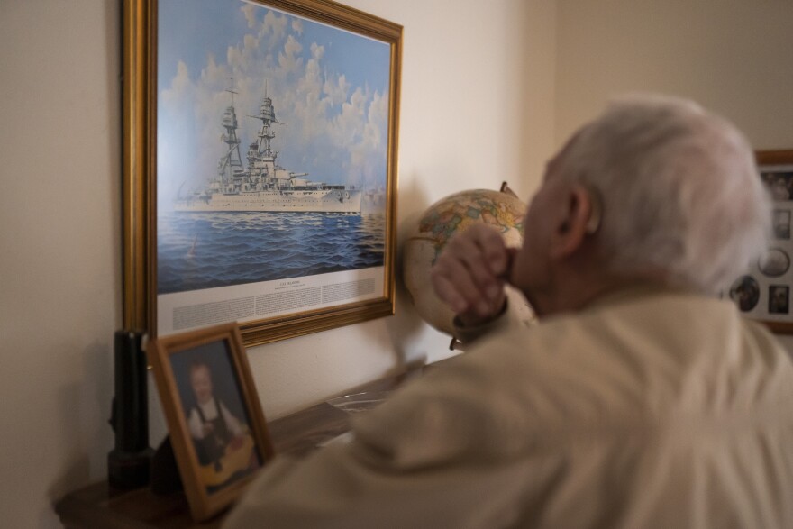 Pearl Harbor survivor and World War II Navy veteran David Russell, 101, looks at a painting of the USS Oklahoma while talking about the attack on Pearl Harbor on Monday, Nov. 22, 2021, in Albany, Ore. (AP Photo/Nathan Howard)