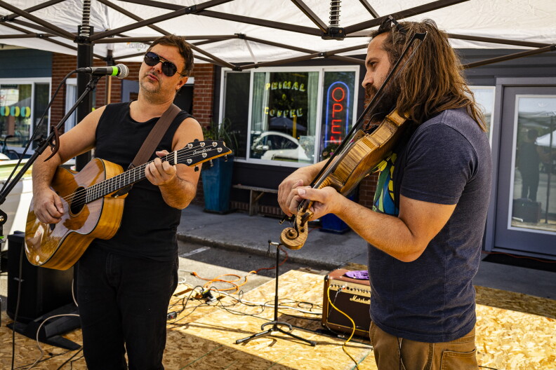 Austin Clark, owner of Primal Coffee on Latah, plays fiddle with his friend Matt Hopper's band The Roman Candles in front of his cafe during the Open Streets event. "I think I knew it would be a good coordinated event, so I was happy to be a part of it and see where it goes," he said.