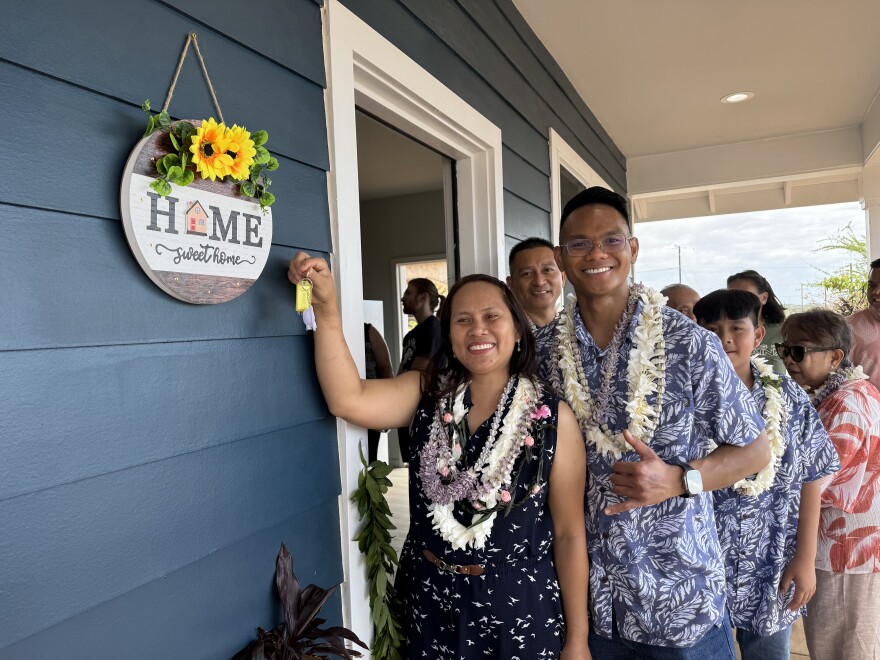 Bhejay Yadao (right front) with his family getting the keys to their newly rebuilt home earlier this year.