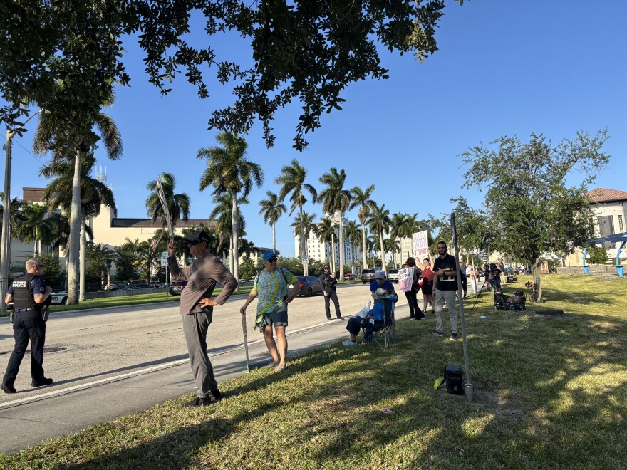 Protesters line Okeechobee Boulevard in West Palm Beach on Friday, May 1, 2026, as President Trump is slated to speak at the Kravis Center. Protesters interviewed by WLRN cite the war in Iran and the Trump administration's immigration agenda as motivators for attending.