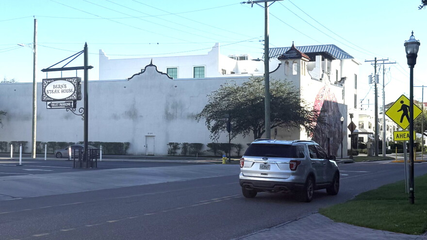 a silver SUV drives south down south howard avenue in front of bern's steak house