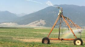 A center pivot beats above a field with some of eastern Oregon's dramatic mountain views in the background. ANNA KING / NORTHWEST NEWS NETWORK