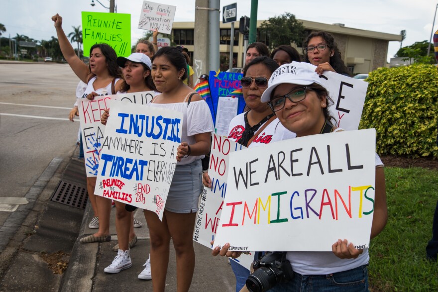 18-year-old Aileen Salas, a daughter of immigrants, holds a sign that says, "We are all immigrants," at the Families Belong Together march in Naples.