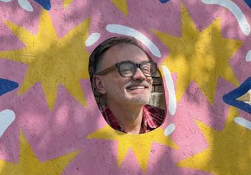 A person poses in a brightly colored art piece.