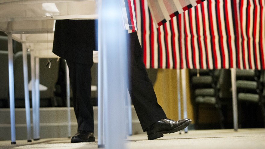 A voter steps out of a voting booth after marking his ballot at a polling site for the New Hampshire primary.