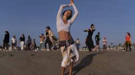 With music playing through wireless headphones, Chase Beckerman, a 37-year-old mother of two children, and other participants dance on the beach during a weekly event hosted by Ecstatic Dance LA on Venice Beach in Los Angeles, Wednesday, Sept. 29, 2021. "Ecstatic dance here at the beach has been my church since May," said Beckerman. "I can come here by myself as a woman and dance. There aren't many places where you can feel safe to do that." (AP Photo/Jae C. Hong)