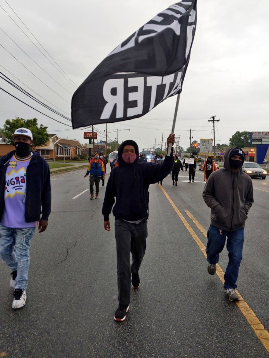  About 50 protesters marching on foot along Ehringhaus Street in Elizabeth City. More protesters following in cars. 