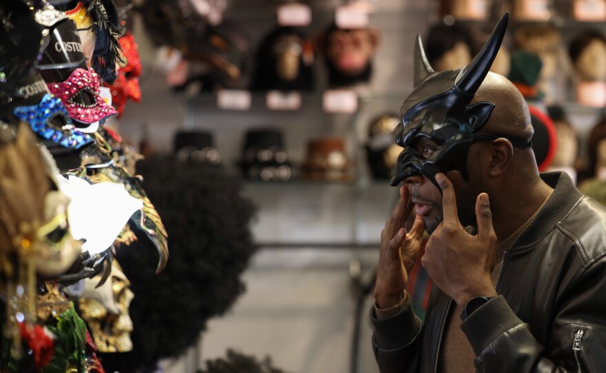 Brandin Jones tries on masks at Arlene’s Costumes while shopping for a Halloween party outfit on Thursday, October 23, 2025.