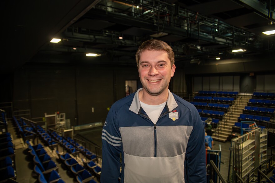 man stands in front of theater being reconstructed
