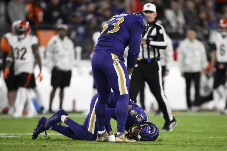Baltimore Ravens safety Kyle Hamilton (14) is injured as linebacker Kyle Van Noy (53) stands over him during the first half of an NFL football game against the Cincinnati Bengals, Thursday, Nov. 7, 2024, in Baltimore. (AP Photo/Nick Wass)