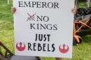 A young protestor holds up a sign at an earlier No Kings event. This week's event will focus on voter participation.