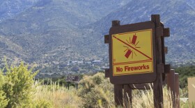 This June 30, 2023 image shows a sign prohibiting fireworks in the Sandia Mountains that border Albuquerque, New Mexico. U.S. Forest Service managers are urging people to use glow sticks and cans of aerosol party string as alternatives to fireworks, but some environmentalists say the string difficult to clean up and should not be used out in nature. (AP Photo/Susan Montoya Bryan)