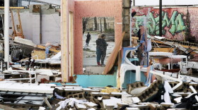 People are reflected in a mirror of a building destroyed by storms Tuesday, March 3, 2020, in Nashville, Tenn. Tornadoes ripped across Tennessee early Tuesday, shredding buildings and killing multiple people. (Mark Humphrey/AP)