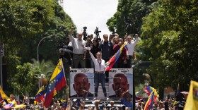 Opposition leader Maria Corina Machado holds a national flag while 