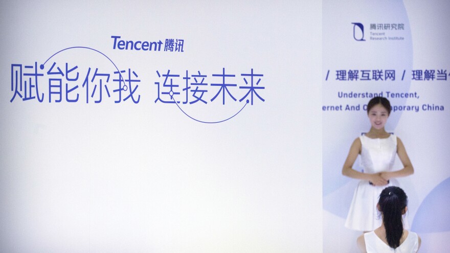 A woman poses for a smartphone photo at a booth for Chinese tech firm Tencent at the Global Mobile Internet Conference (GMIC) in Beijing, last year. Tencent was one of a number of tech companies singled out in a new report on gender discrimination in China.