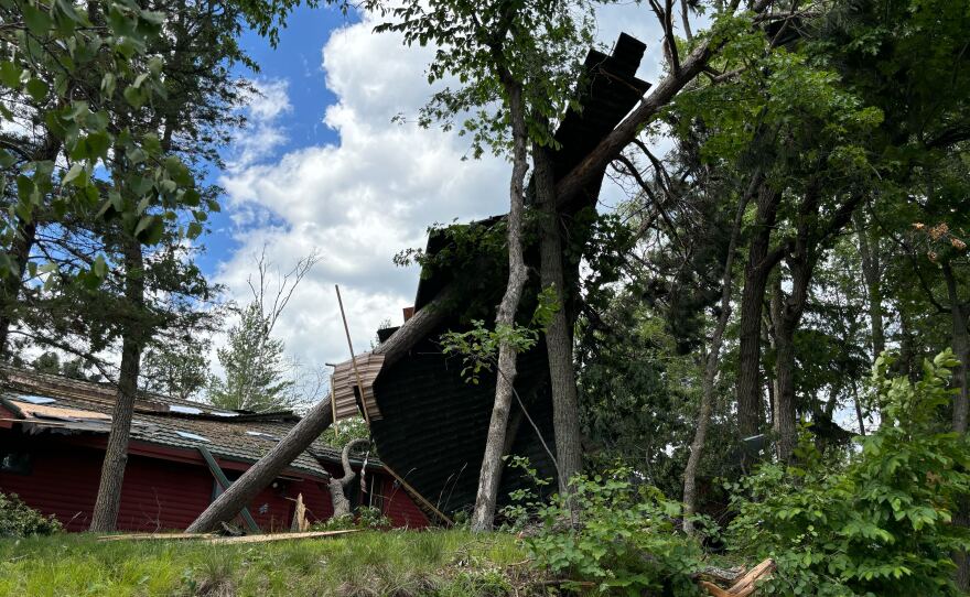 A section of roof lies against a tree following a Wednesday, June 12, 2024, tornado that touched down near Clamshell Lake in the western Whitefish Chain of Lakes.