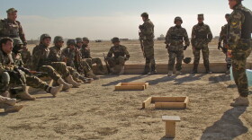 Iraqi policeman Lt. Ahmed, center, and members of his special weapons and tactics team look on during training at Convoy Support Center Cedar in Iraq’s Dhi Qar province in December 2008.