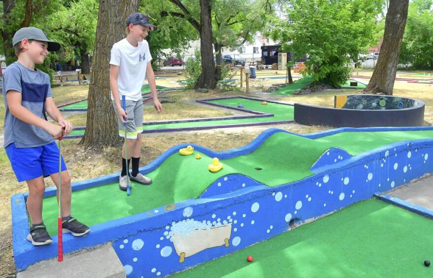 Kolter and Tristen Roberts laugh as they play at Cache Valley Mini Golf on Friday in Logan.