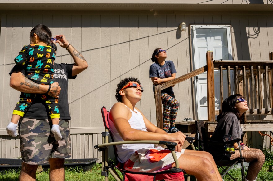 La famille Flores observe samedi l'éclipse solaire annulaire à Kerrville, au Texas.