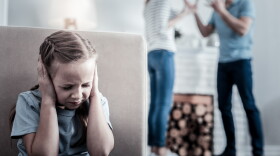 Too much stress. Little nervous girl closing her ears while hearing quarrels