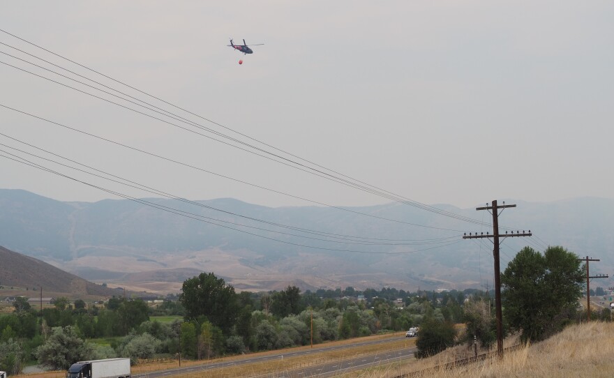 A helicopter bound for the Rocky Canyon Fire carries water over the Henefer Valley and Interstate 84 at noon Aug. 10, 2026.