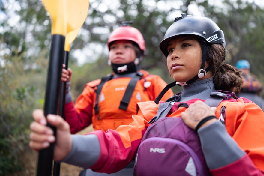 Thirteen-year-old Scarlett Schroeder, left, and Coley Miller, 14, who belong to tribes on the Upper Klamath, stand with their paddles on the banks of the Klamath River. The Paddle Tribal Waters group of 13- to 20-year-olds from more than six tribes in the Klamath Basin, along with several instructors, were among the first in a century to paddle the free-flowing river after several major hydropower dams were removed last year.