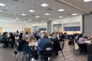 Groups of Columbia residents sit around circular tables at a meeting of the Steering Committee on Homelessness on August 27, 2026.