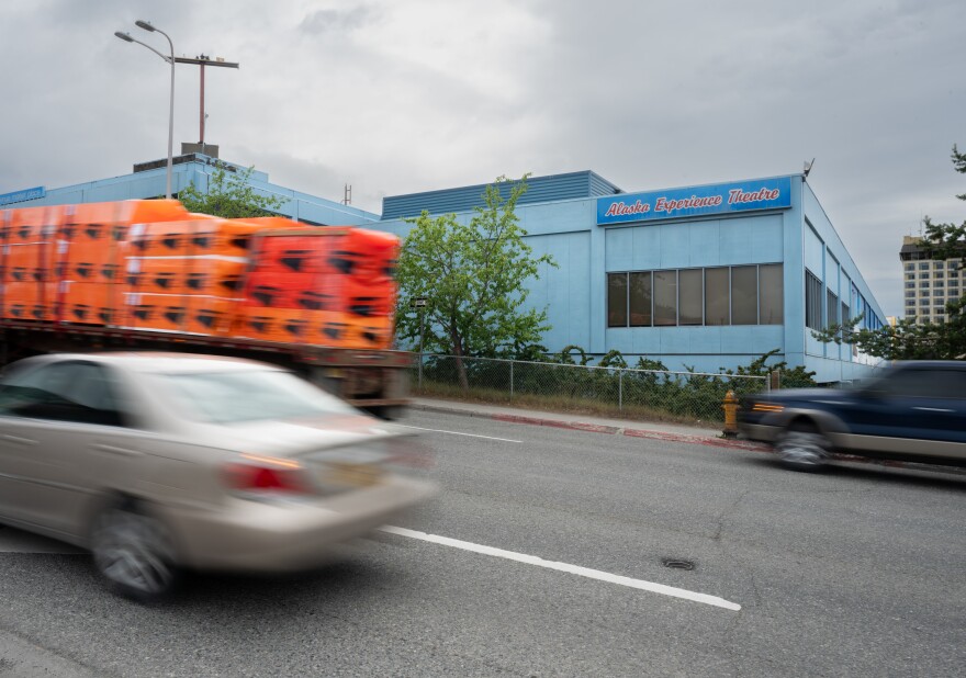 cars passing by a movie theater
