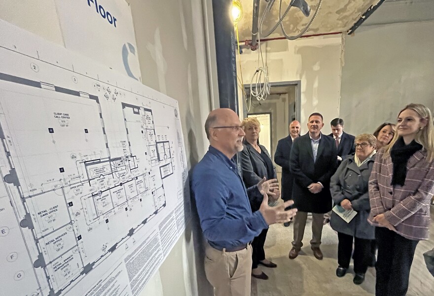 Stephen Peterson, left, Senior Project Engineer at L.R. Costanzo Co., talks about renovation of the historic Scranton Electric Building for guests including Scranton Mayor Paige Cognetti, right, and Lackawanna County Commissioner Bill Gaughan,