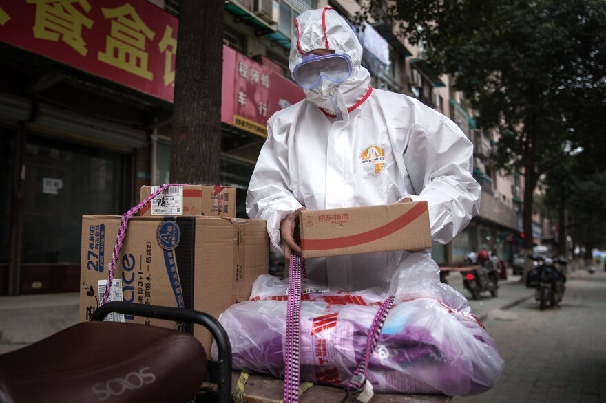 A worker in protective clothing with a package. In addition to encouraging couriers to wear this gear, the Chinese Center for Disease Control and Prevention has published a guide for the deliverymen, encouraging them to wash their hands and disinfect themselves before going home.