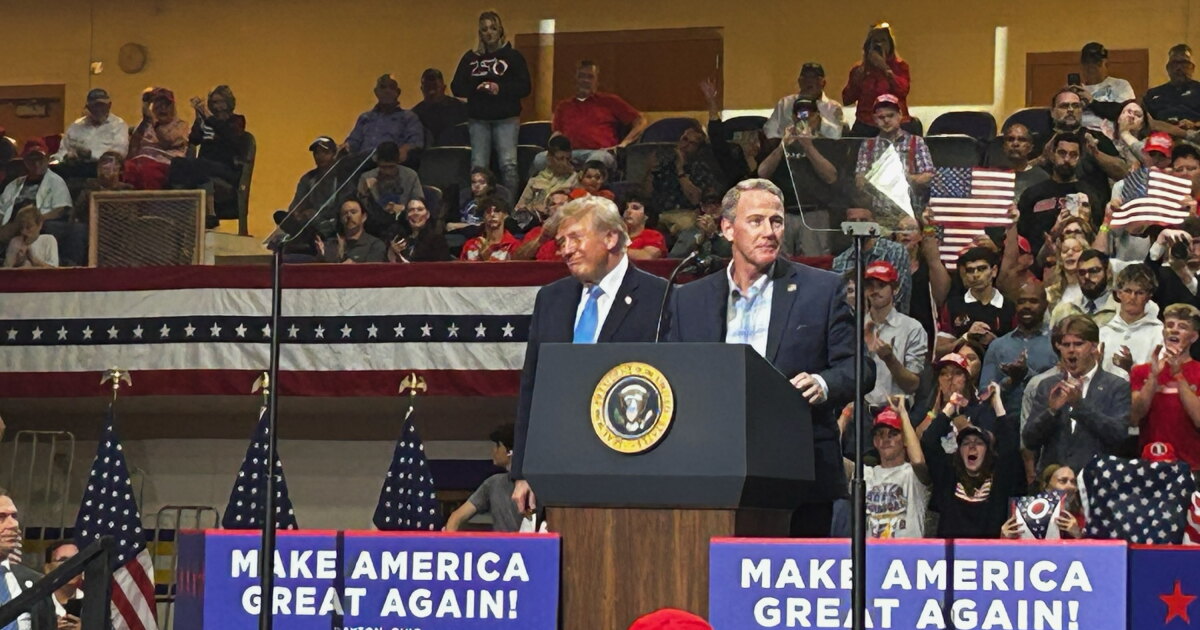 Photo: wyso.org U.S. Sen Jon Husted and President Donald Trump stand on stage together at a rally in Vandalia, Ohio, with a crowd of
