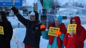Supporters of the Teamsters Local 959 bus drivers wave signs near the Mat-Su Borough School District building on Feb. 15, 2023. (Wesley Early/Alaska Public Media)