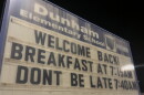 A sign outside Dunham Elementary School reading "Welcome Back! Breakfast at 7:15 AM, Don't Be Late 7:40 AM"