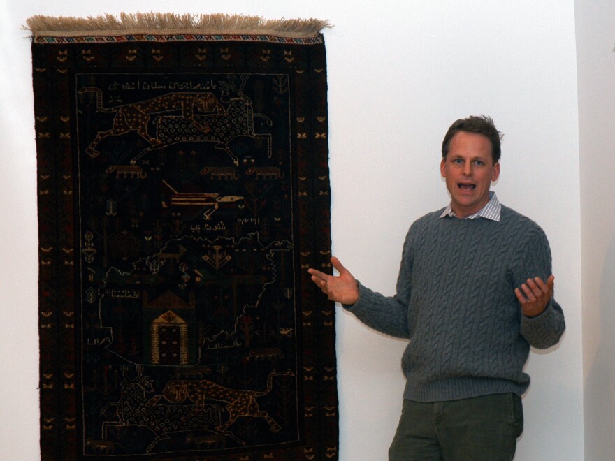 Kevin Sudeith, shown at a 2005 exhibit in Davidson, N.C., collects, <a href="http://warrug.com">shows and sells Afghan war rugs.</a>