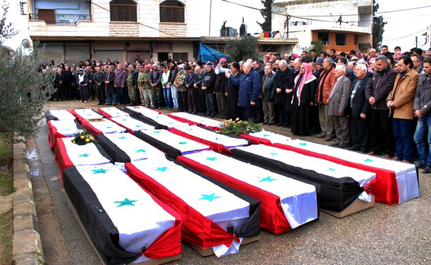 Syrians pray on Jan. 10 beside the coffins of people killed by a car bomb a day earlier in the central city of Hama. Syrian peace talks are planned next week in Geneva, Switzerland.