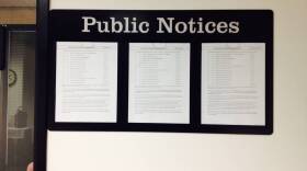 A posting of public meetings outside an office at the Indiana Government Building South