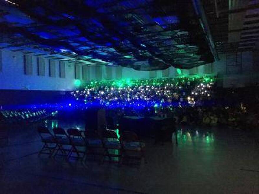 Cumberland Elementary students shine lights in their gymnasium to emulate fireflies as Gov. Holcomb arrives to sign the bill.