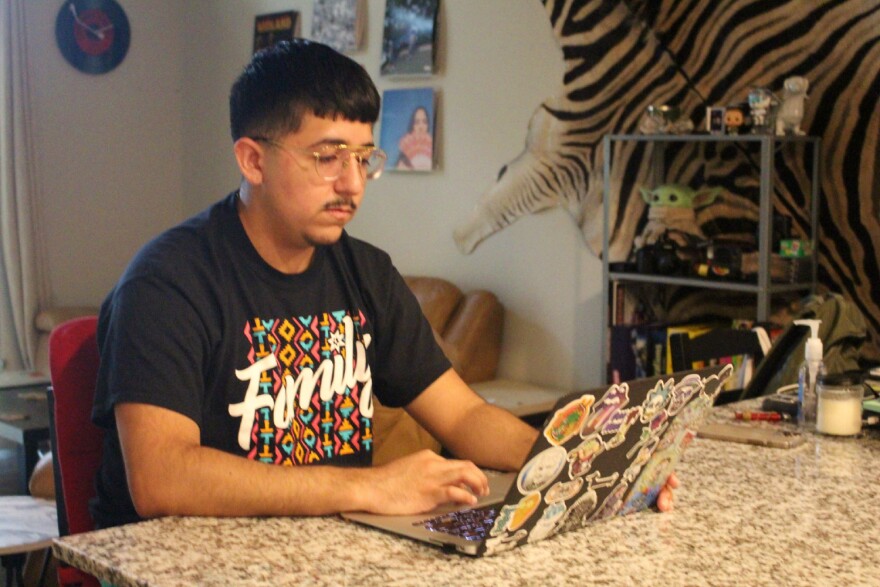  Andres Mendoza does school work on his laptop.