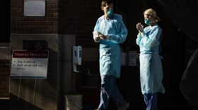 Healthcare workers stand by at a COVID-19 temporary testing site at Abington Hospital in Abington, Pa., Wednesday, March 18, 2020.