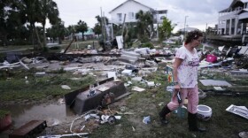FILE - Jewell Baggett walks amidst debris strewn across the yard where her mother's home had stood, in Horseshoe Beach, Fla., after the passage of Hurricane Idalia, on Aug. 30, 2023. 