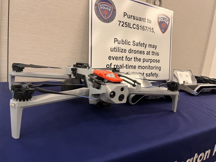 A grey drone sits on a blue table