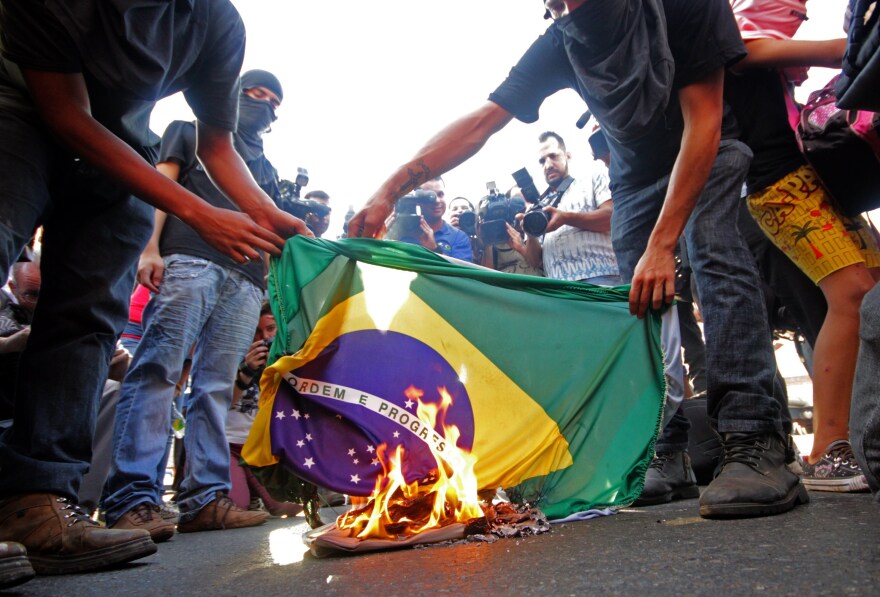 Demonstrators in Goiania, Brazil, on Tuesday burn a Brazilian flag in protest of the upcoming FIFA World Cup.